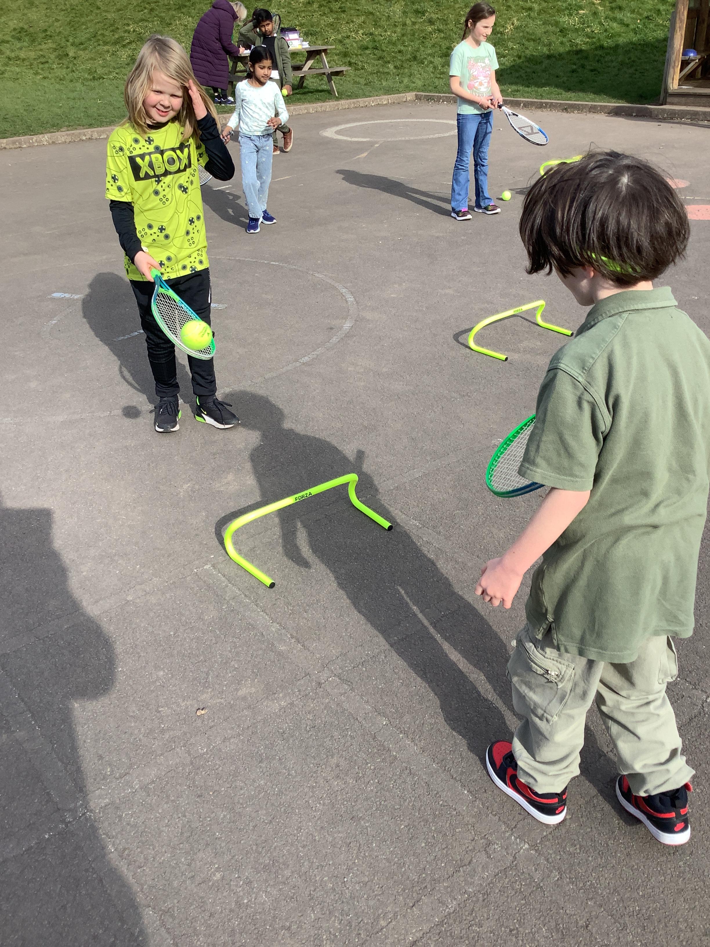 Year 3 honing their tennis skills. We have started to use a 'mini' net.
